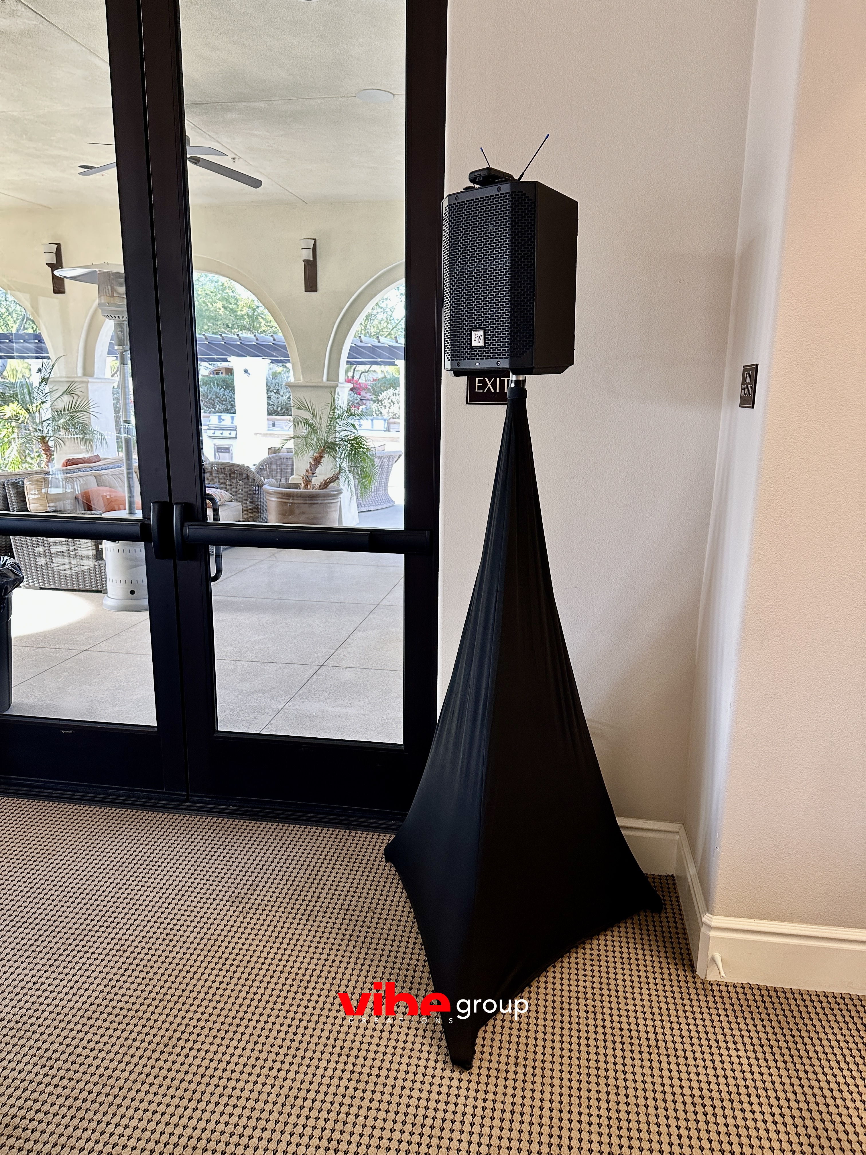 Cocktail hour speaker on a covered stand by patio doors